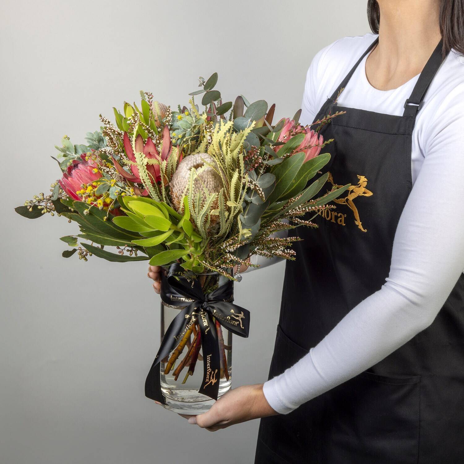 bouquet, flowers, protean foliage?, greenery, pink flowers, bucket?, vase, hand-tied,  floral arrangement, flower bouquet, protein evergreen, greenery, pink protea, floral arrangement, bouquet, floral arrangement, proteas, greenery, bouquet in vase
