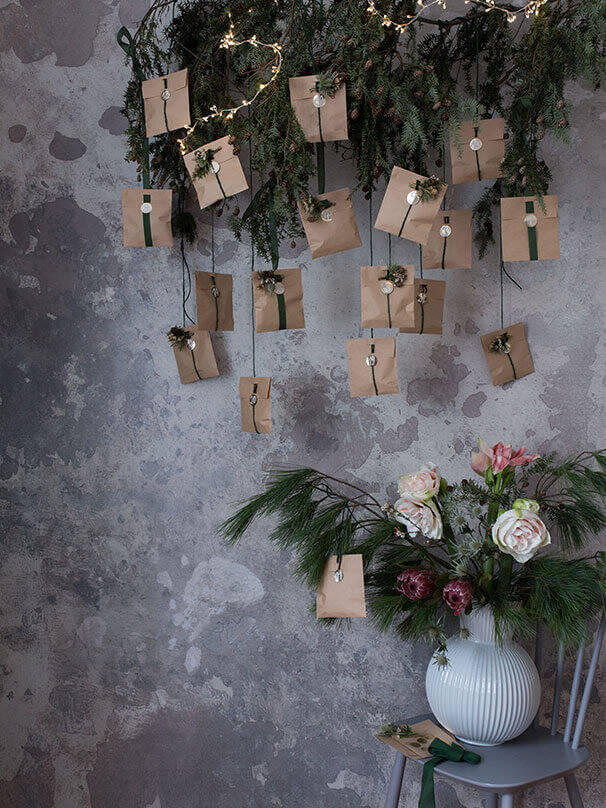 Der fertige DIY Adventskalender hängt an einem Deko Tannenzweig