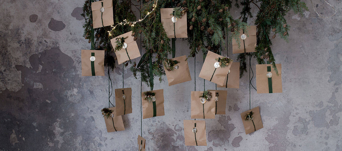 Der fertige DIY Adventskalender hängt an einem Deko Tannenzweig