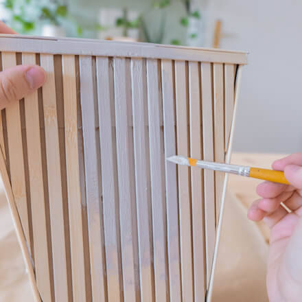 Die Flower-Bag inklusive angebrachter Bambusstäbe, werden mit Kreidefarbe in Taupe angemalt.